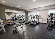 Thumbnail 9 of 19 - A spacious gym with treadmills, exercise bikes, and dumbbells.