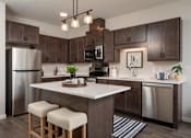 Thumbnail 8 of 19 - A modern kitchen with a white island and wooden cabinets.