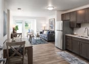 Thumbnail 5 of 25 - a kitchen and living room with a refrigerator and a table