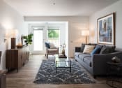 Thumbnail 20 of 25 - a living room with a gray couch and a glass coffee table