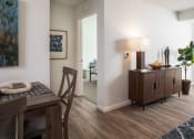Thumbnail 22 of 25 - a living room with a dining room table and a door to a bedroom