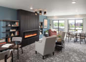 Thumbnail 8 of 25 - a living room with a fireplace and a table and chairs