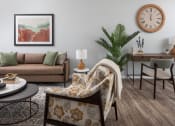 Thumbnail 9 of 25 - a living room with a couch and a clock on the wall