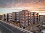 Thumbnail 1 of 24 - Apartment building with a street in front of it.