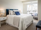 Thumbnail 8 of 24 - A bedroom with a large bed and a window overlooking a street.