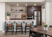 Thumbnail 20 of 24 - A kitchen with a bar area and a dining table.