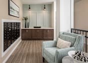 Thumbnail 15 of 24 - A grey armchair with a pillow is in front of a cabinet with glass doors.