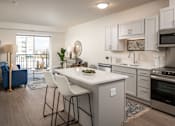 Thumbnail 12 of 24 - A kitchen with a white countertop and a blue sofa.