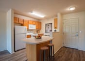 Thumbnail 8 of 11 - a kitchen with white appliances and wooden cabinets and a island with three stools