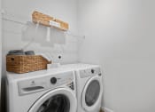Thumbnail 24 of 43 - a laundry room with a washing machine and a basket on top of it