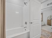 Thumbnail 18 of 43 - a white bathroom with a shower and a tub