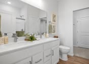 Thumbnail 9 of 43 - a white bathroom with a large mirror and a toilet
