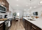Thumbnail 19 of 62 - A modern kitchen with dark wood cabinets and white countertops.