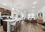 Thumbnail 18 of 62 - A modern kitchen with a dining area and a living room.