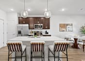 Thumbnail 23 of 62 - A modern kitchen with a white island and striped barstools.
