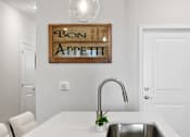 Thumbnail 26 of 62 - A kitchen with a white counter top and a sink.
