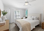 Thumbnail 27 of 62 - A bedroom with a large bed and a ceiling fan.