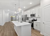 Thumbnail 3 of 62 - A modern kitchen with white cabinets and a large island.