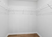 Thumbnail 36 of 62 - Empty room with white walls and wooden floor.