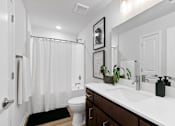 Thumbnail 34 of 62 - A bathroom with a white toilet and a white sink.