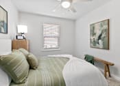 Thumbnail 41 of 62 - A bedroom with a bed, nightstand, and a painting on the wall.