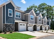 Thumbnail 42 of 62 - A row of houses with garages are shown in the image.