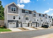 Thumbnail 44 of 62 - A row of modern townhouses with garages and driveways.