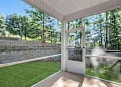 Thumbnail 6 of 62 - A white door is open to a backyard with a green lawn and a stone wall.