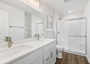 Thumbnail 59 of 62 - A white bathroom with a walk-in shower.