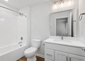 Thumbnail 58 of 62 - A white bathroom with a toilet, sink, and bathtub.