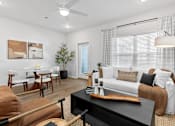 Thumbnail 14 of 62 - A living room with a brown couch, a black coffee table, and a white sofa.