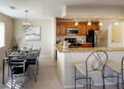Thumbnail 11 of 49 - A kitchen with a dining table and chairs.