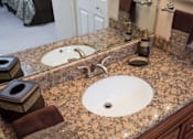Thumbnail 10 of 49 - A bathroom with a granite countertop and a white sink.