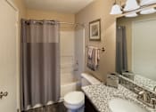 Thumbnail 3 of 49 - A bathroom with a toilet, sink, and shower curtain.
