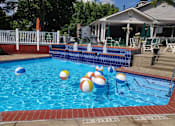 Thumbnail 19 of 49 - A pool with a white fence and a house in the background.