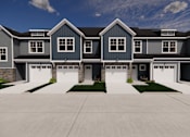 Thumbnail 4 of 15 - A large, modern house with a grey and white exterior and a stone pillar.