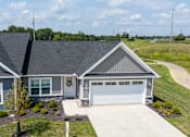 Thumbnail 27 of 29 - A house with a grey roof and a white garage door.
