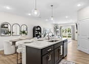 Thumbnail 24 of 39 - A modern kitchen with a large island and a view of the backyard.