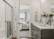 Thumbnail 25 of 39 - A bathroom with a white door and a mirror.