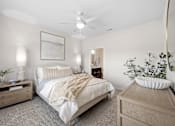 Thumbnail 20 of 39 - A bedroom with a bed, nightstands, and a ceiling fan.