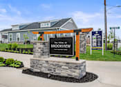 Thumbnail 38 of 39 - A sign for The Villas at Brookview Apartment Homes stands in front of a building.