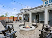 Thumbnail 31 of 39 - A patio with a fire pit and chairs.