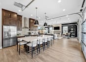 Thumbnail 37 of 39 - A modern kitchen with a large island and stainless steel appliances.