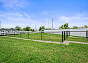 Thumbnail 34 of 39 - A grassy field with a fence and a clear blue sky.