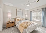 Thumbnail 8 of 39 - A bedroom with a large bed and a ceiling fan.