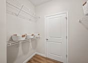 Thumbnail 12 of 39 - A white pantry with a white door and shelves with bowls on them.
