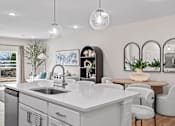 Thumbnail 7 of 19 - A modern kitchen with a large island and a dining area.