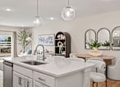 Thumbnail 6 of 39 - A modern kitchen with a large island and a dining area.