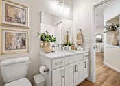 Thumbnail 13 of 39 - A white bathroom with a toilet, sink, and mirror.