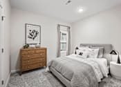 Thumbnail 8 of 19 - A bedroom with a bed, nightstand, and dresser.